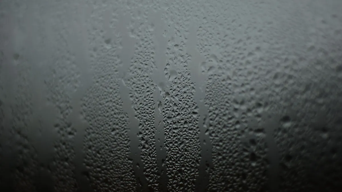 Moisture droplets forming on the cold surface of an indoor window